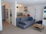 Wohnzimmer mit Blick zur offenen Küche - Trendige 1 Zimmer Neubau-Wohnung mit Balkon und Carport in Bönningstedt zu vermieten !!!